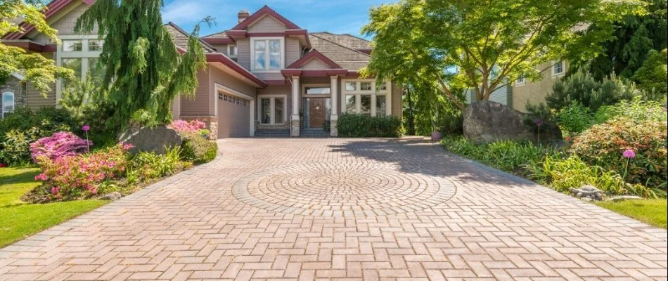 Paver driveway in Cary, NC, with plants by a house.