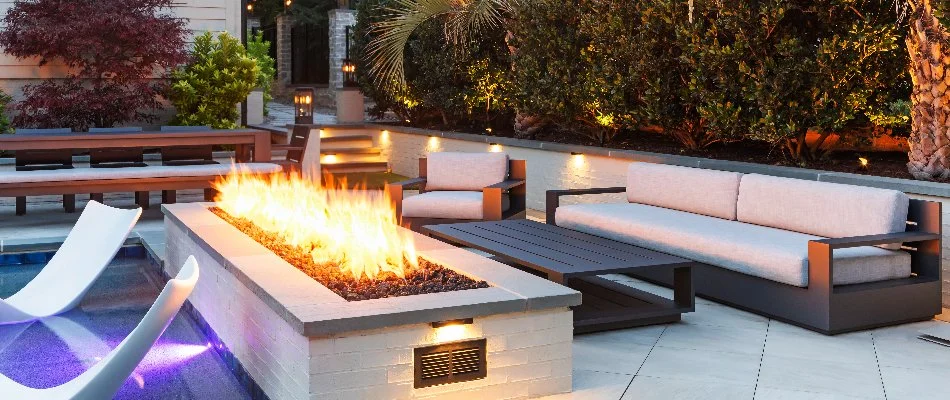 Rectangular fire pit with seating and a table in Wake Forest, NC.