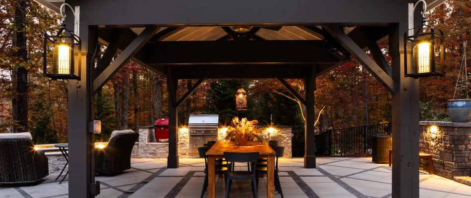 Table underneath a pavilion in Garner, NC, with an outdoor kitchen.